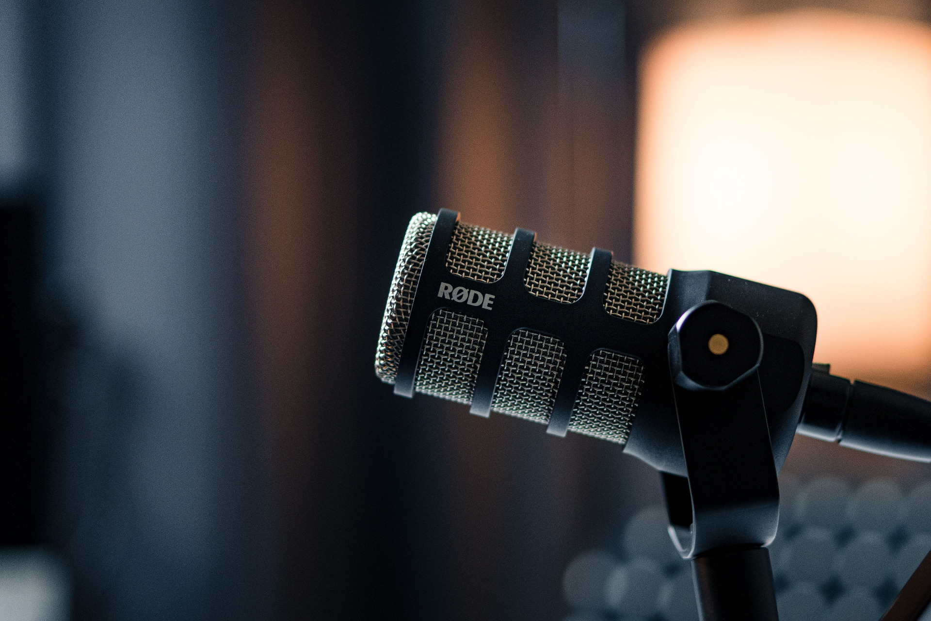 A studio microphone lit by warm light